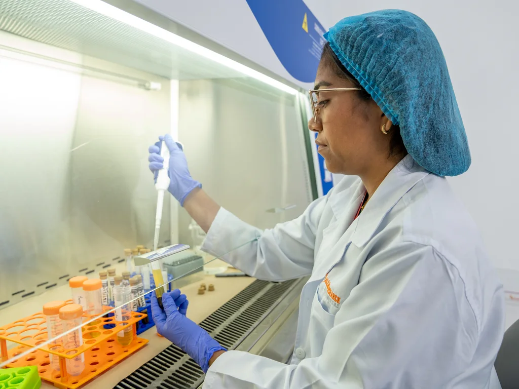 Allied laboratory professional using a pipette inside a biosafety cabinet.